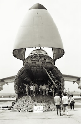 An airplane taking off with cargo containers visible inside the open cargo hold.