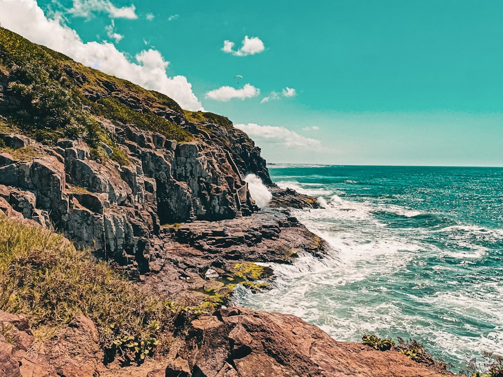 a rocky beach with a large body of water in the background