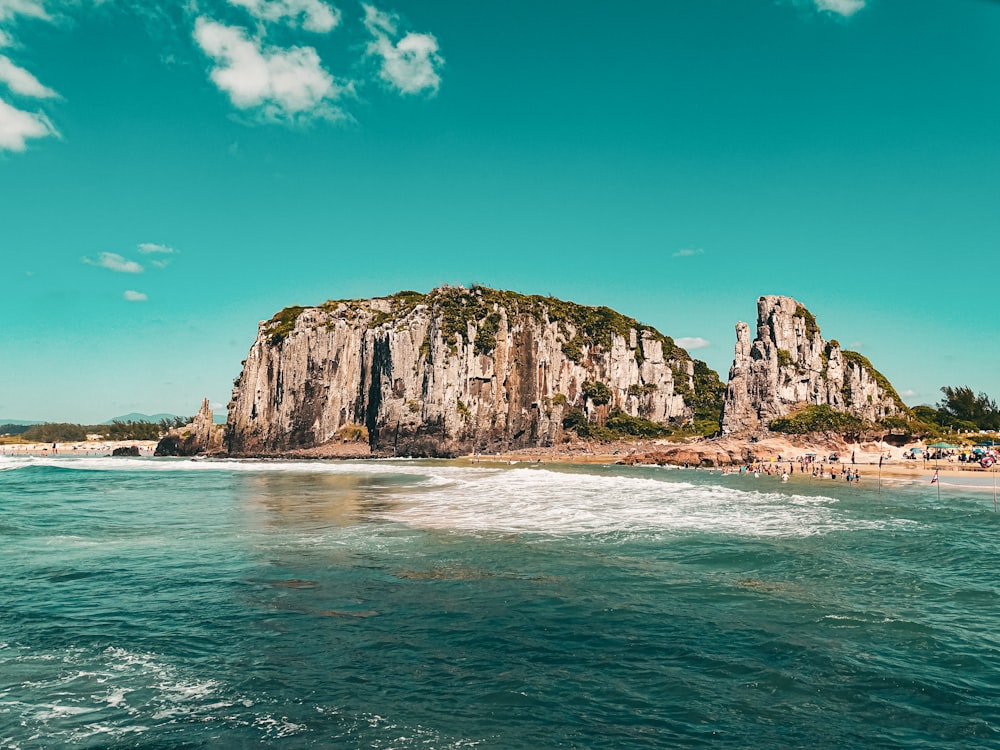 a rocky island with a beach and blue sky
