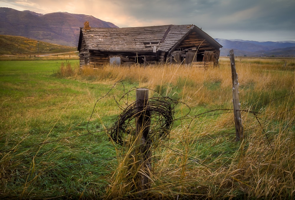 a wooden building in a field