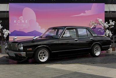 Side view of a restored sedan parked outside with a scenic Utah mountain backdrop.