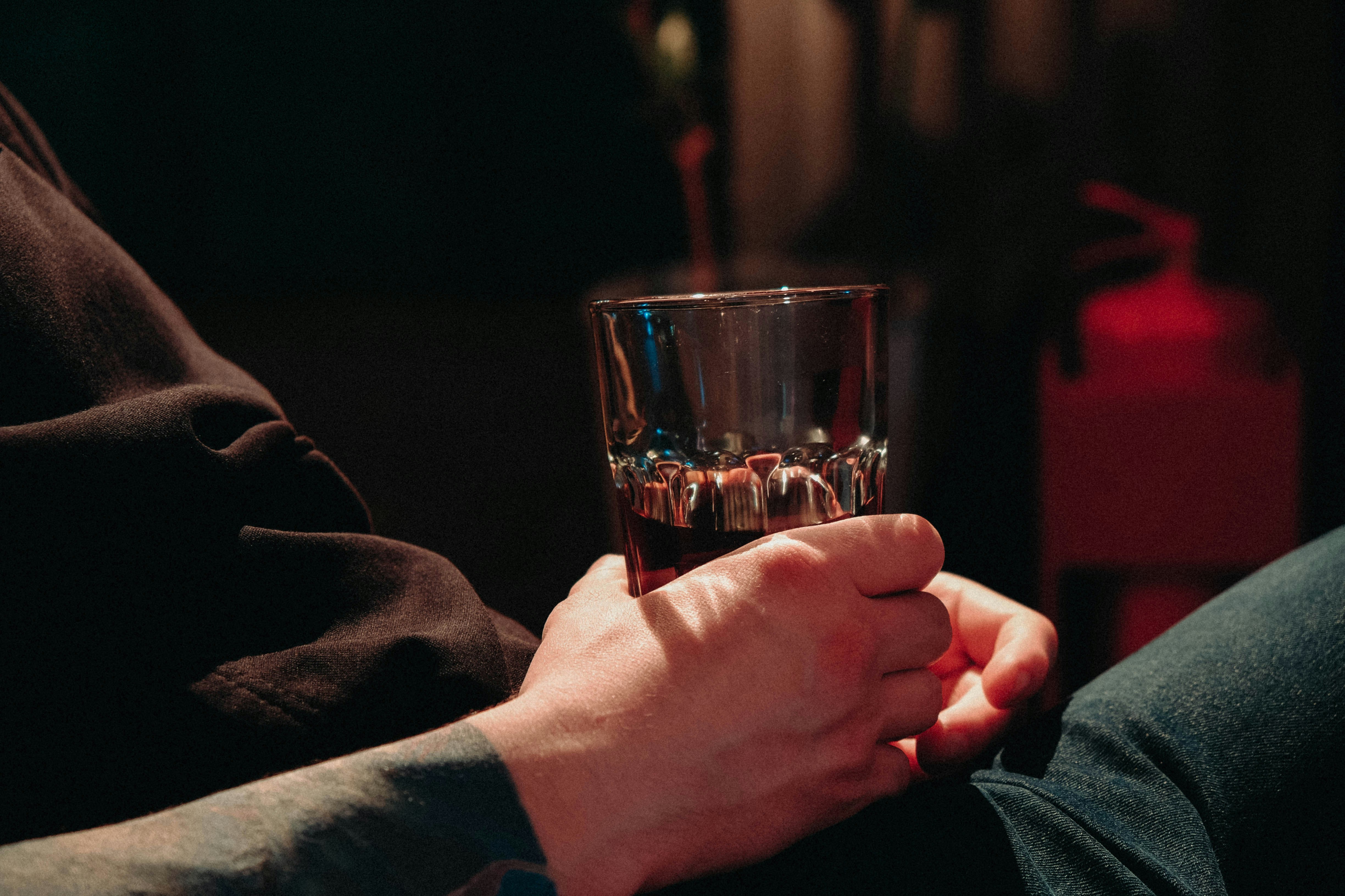 a person holding a glass of liquid