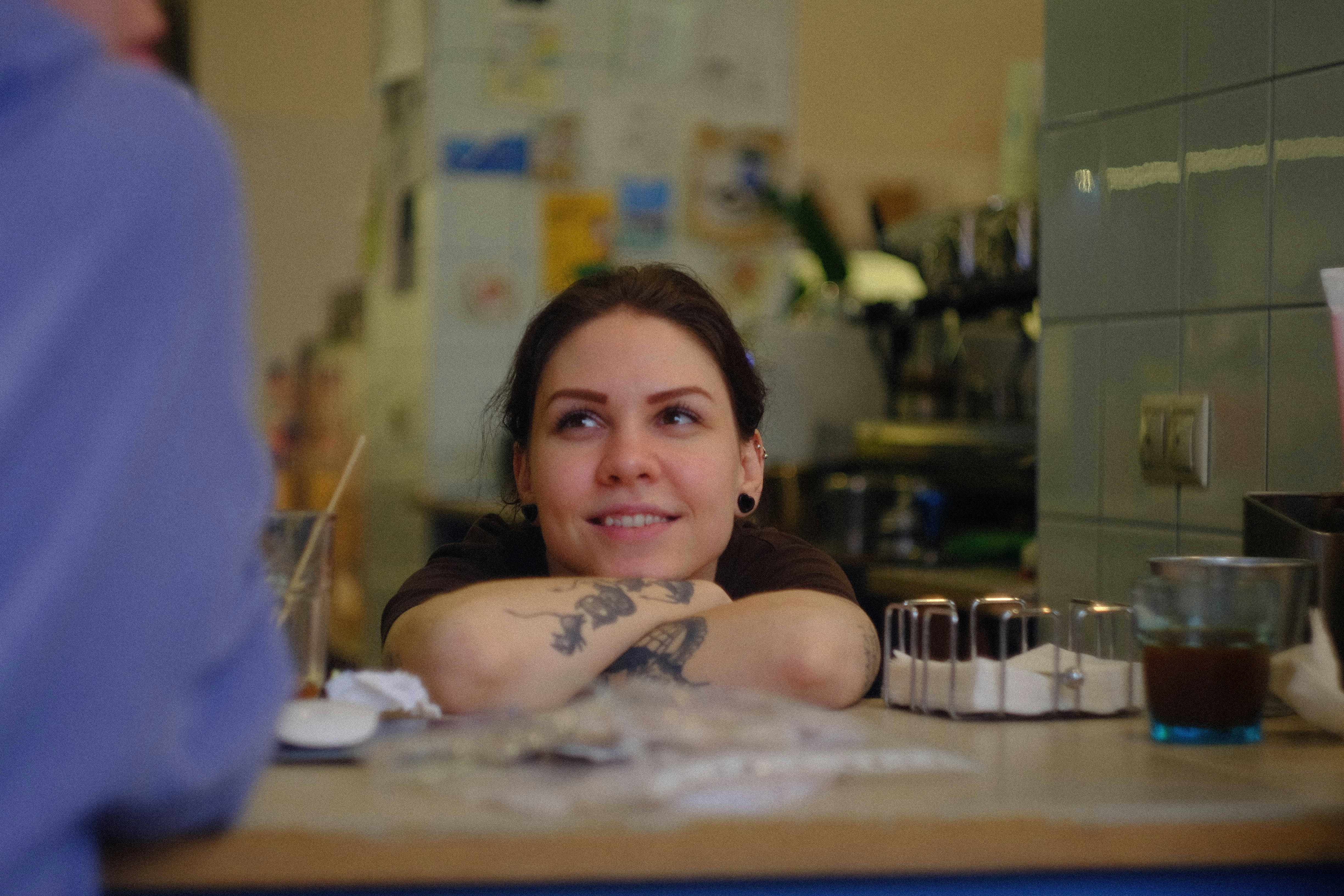 a person with tattoos sitting at a table