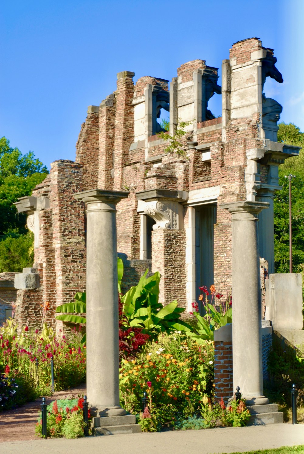 a stone building with pillars and plants