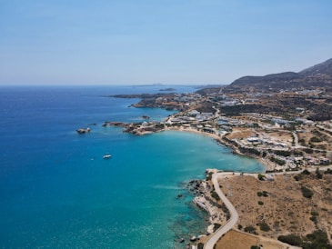 a beach with a body of water and a town by it