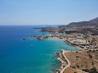 a beach with a body of water and a town by it