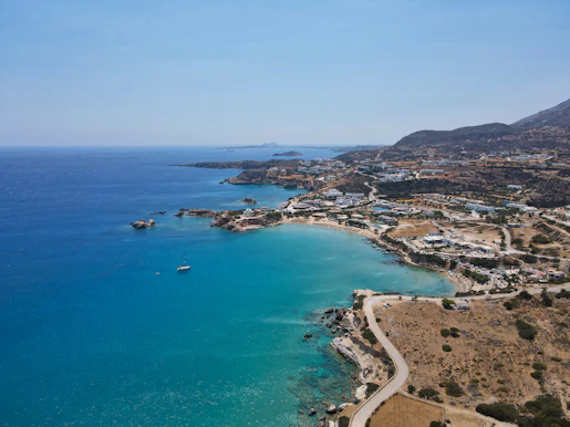 a beach with a body of water and a town by it