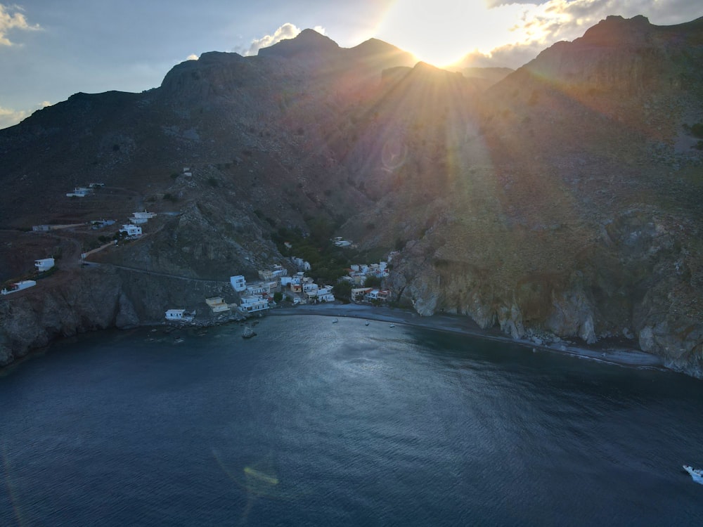 a body of water with houses and mountains in the background