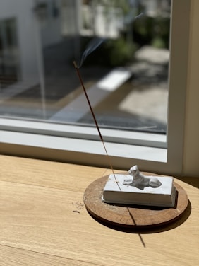 A serene scene of incense sticks burning in a peaceful setting, surrounded by natural elements.