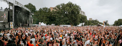 A focused operations director coordinating event logistics on-site at a large outdoor festival.