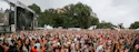 A focused operations director coordinating event logistics on-site at a large outdoor festival.