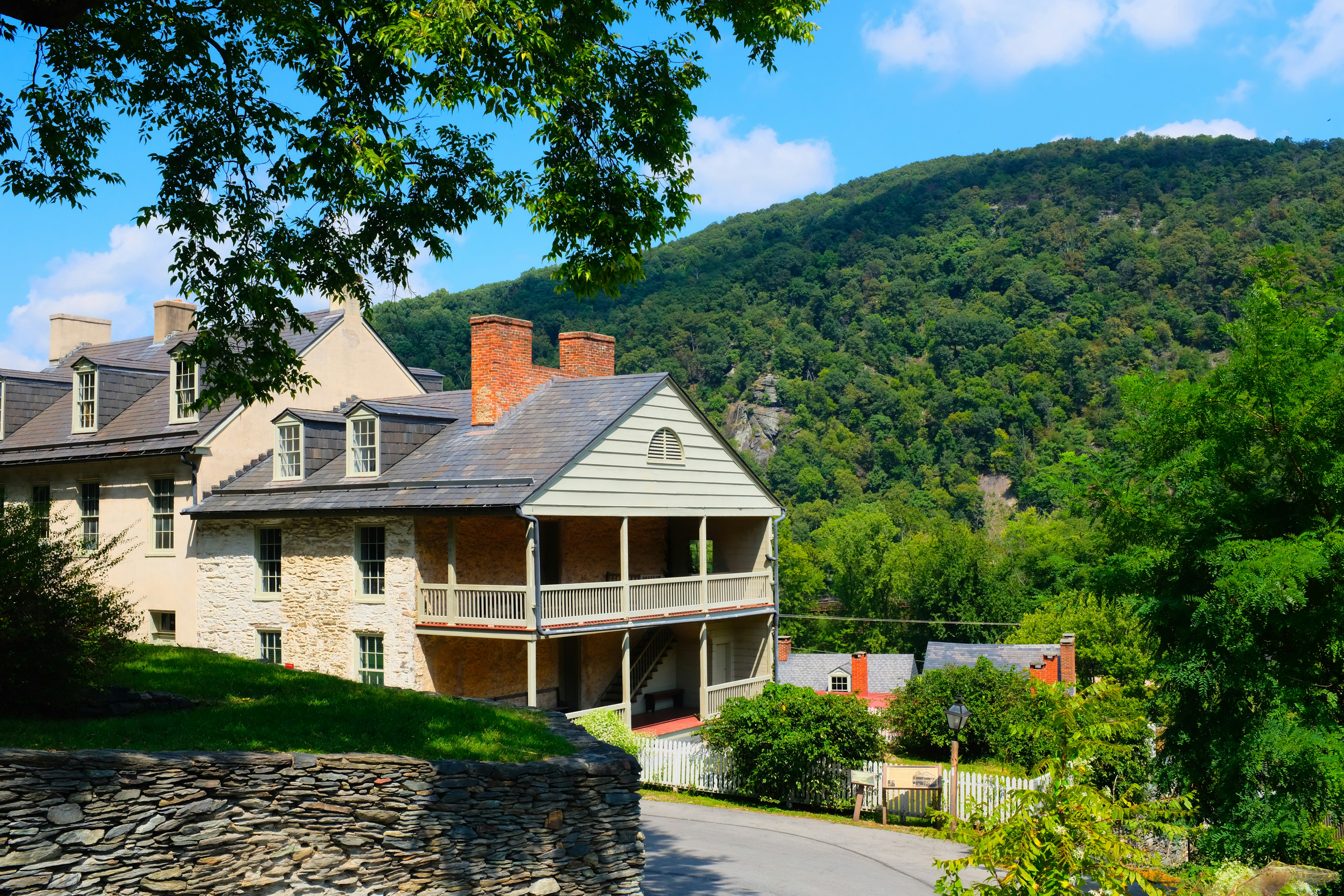 a large house with trees around it, Harpers Ferry is a town in West Virginia. Paths wind through Harpers Ferry National Historical Park, which has 19th-century buildings, a Civil War Museum and John Brown’s Fort, a key site in an 1859 abolitionist raid. The location where the Potomac and Shenandoah rivers meet, known as The Point, offers views of Maryland and Virginia. The Appalachian Trail Visitor Center has exhibits on the long-distance hiking trail.