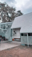 A sleek gray commercial canopy covering a cafe terrace on a sunny day