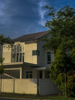 Close-up of a villa’s minimalist facade with forest-green shutters against crisp white walls.