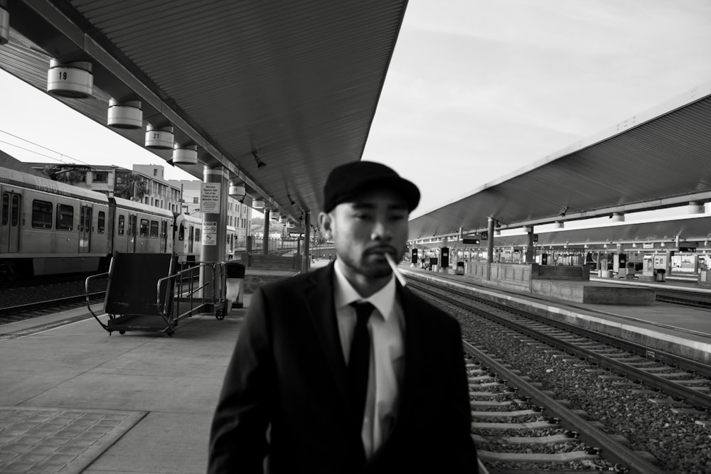 a man in a suit standing at a train station