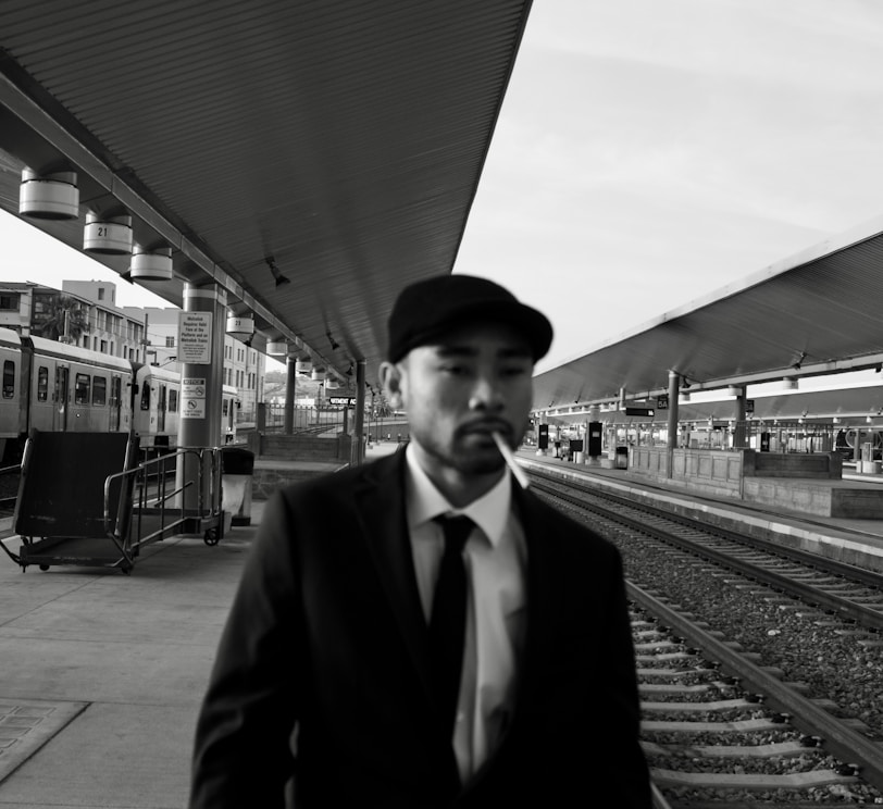 a man in a suit standing at a train station