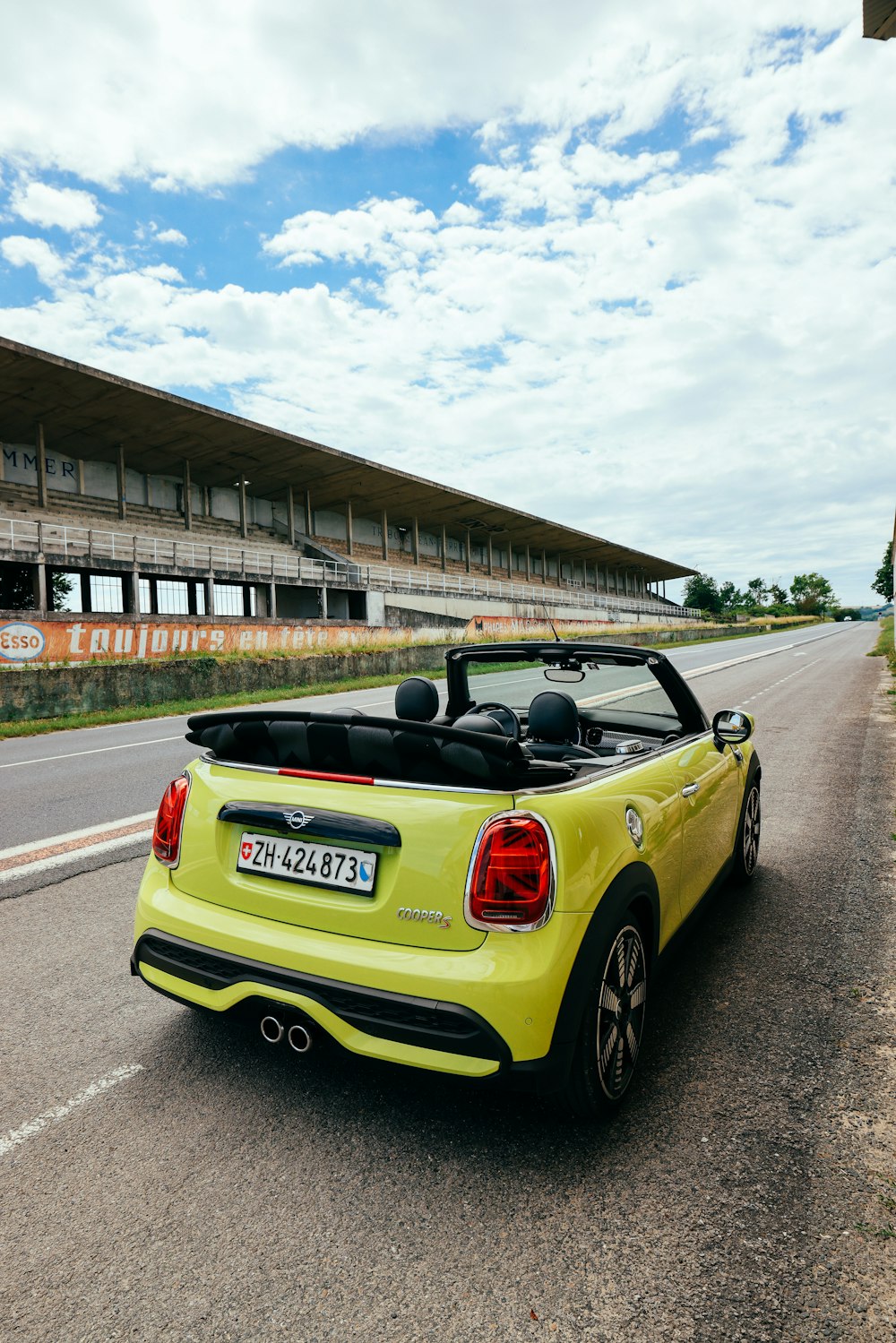 a yellow sports car on a road