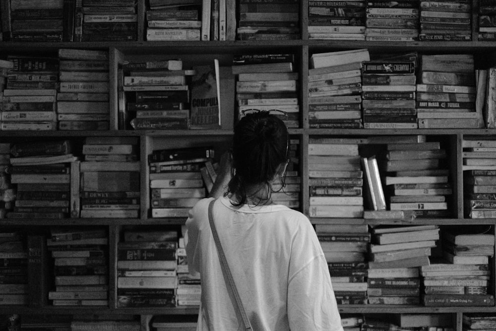 a person looking at a shelf of books