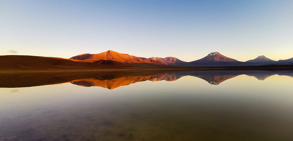 a body of water with mountains in the background