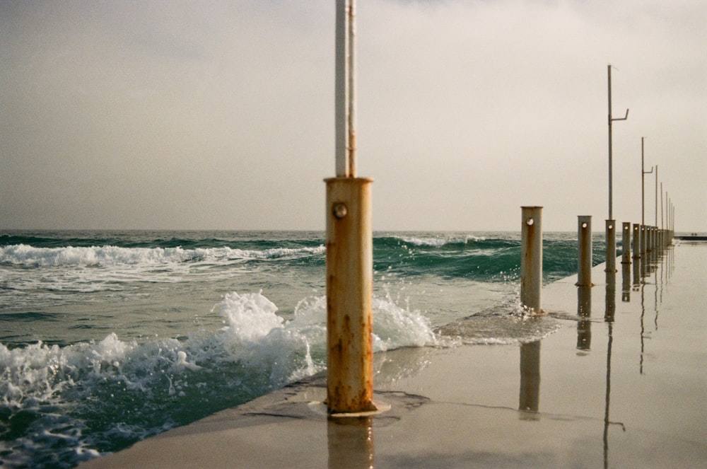 a group of wooden poles in the ocean