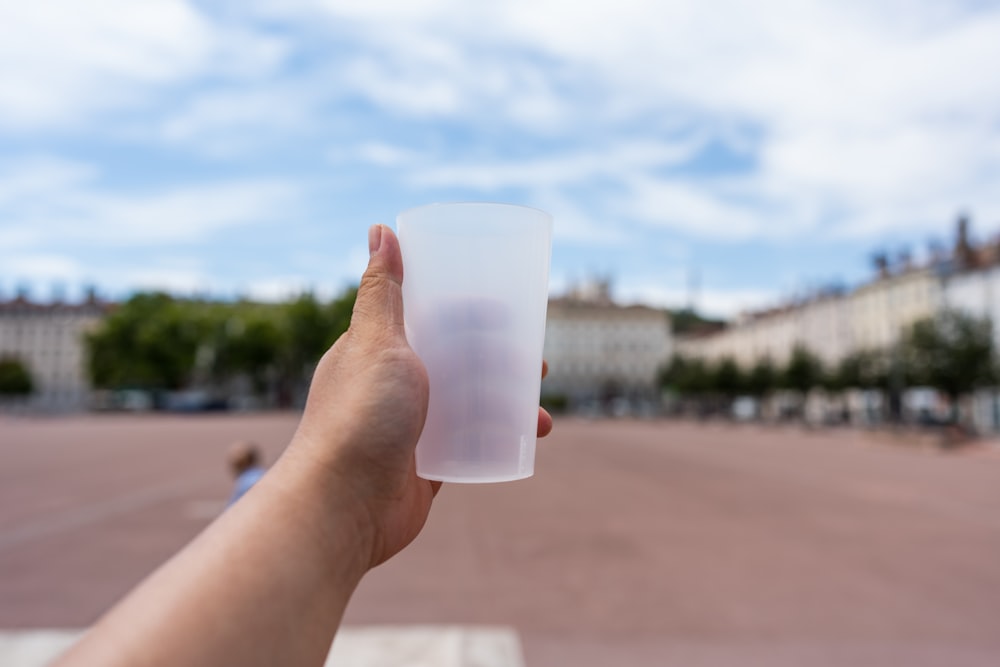 a hand holding a cup