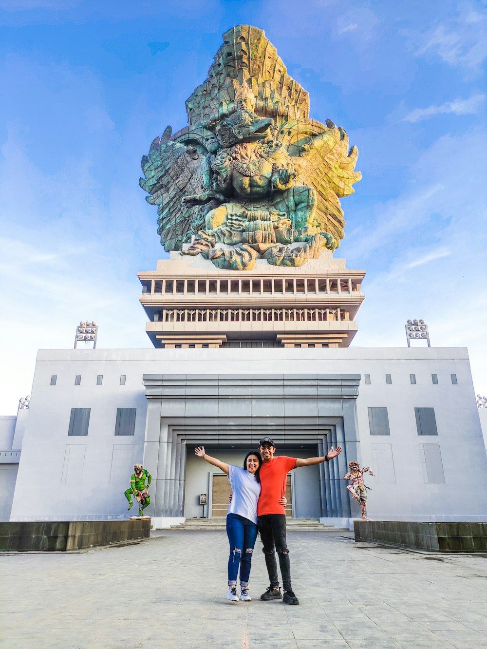a man and woman posing in front of a building with a tower