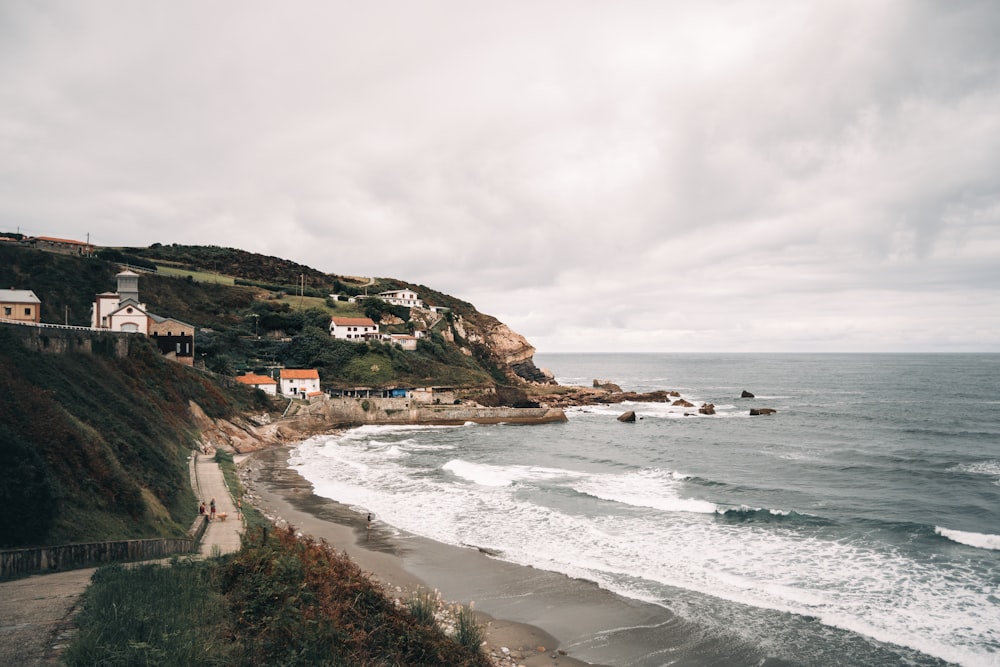 a beach with houses and a hill