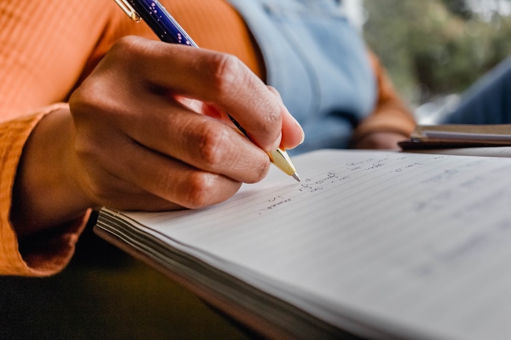 a person writing on a piece of paper