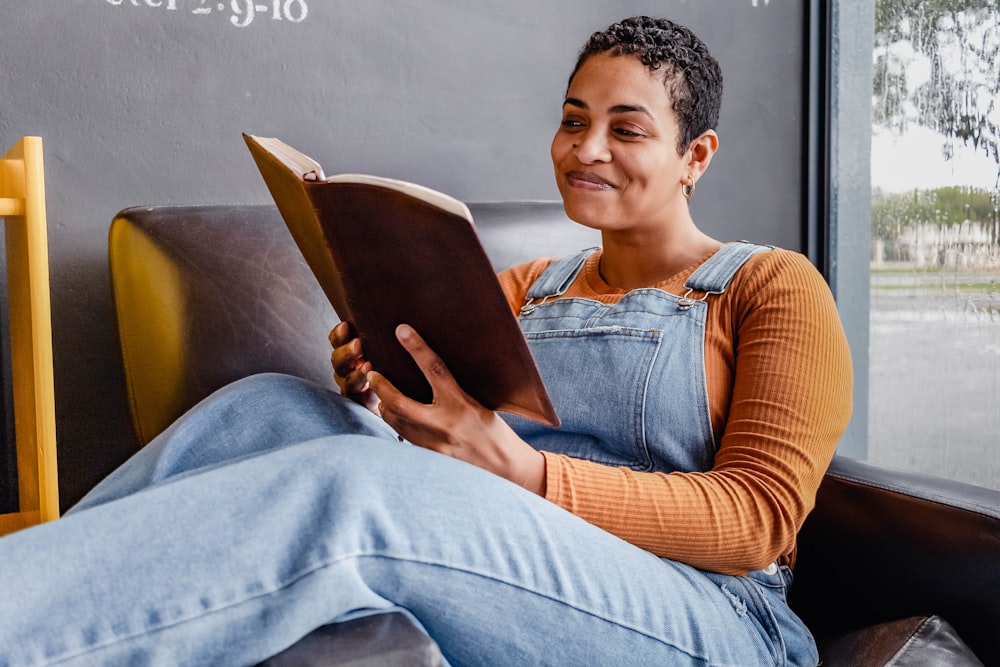 a person sitting on a couch reading a book