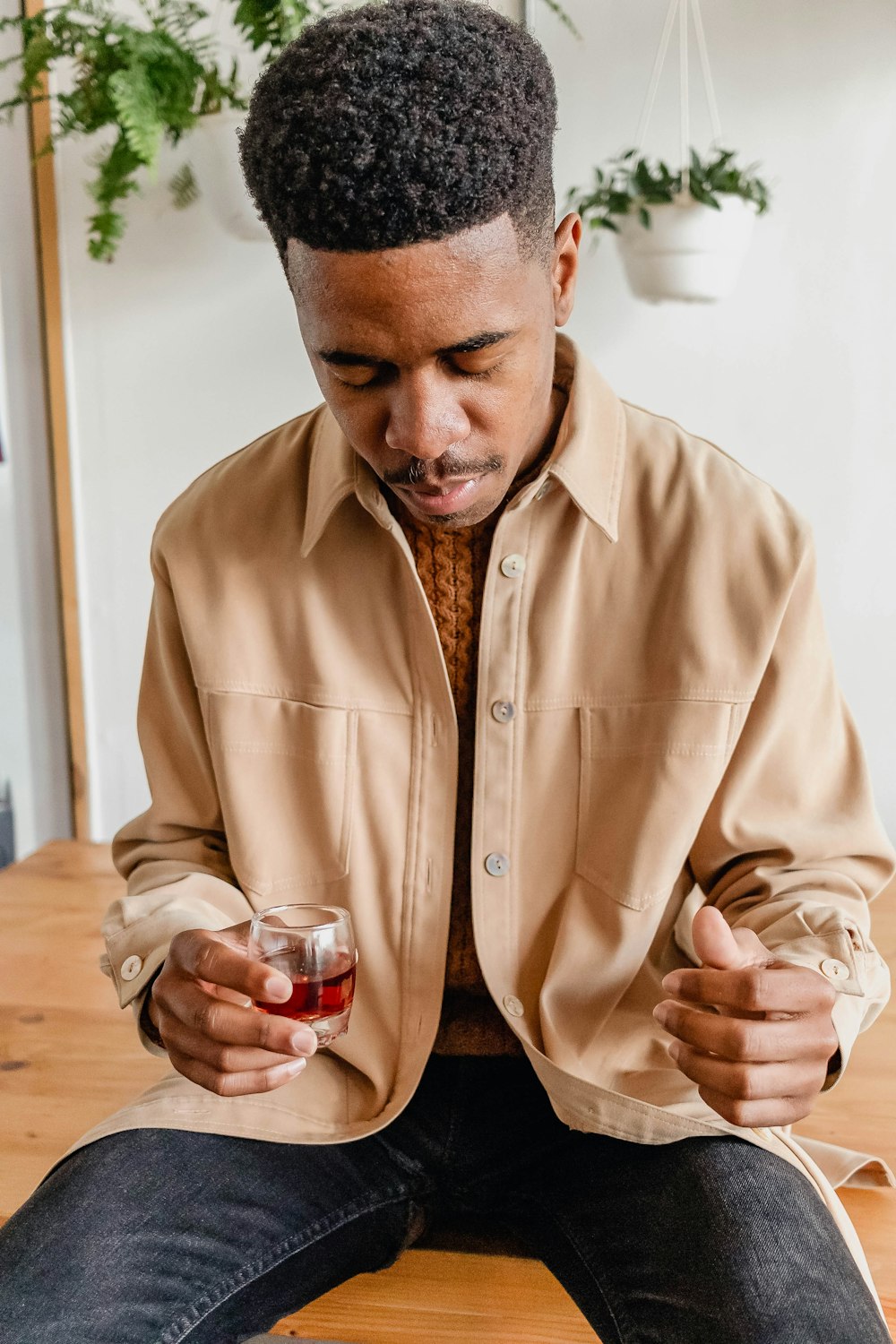 a man sitting down and holding a glass of wine