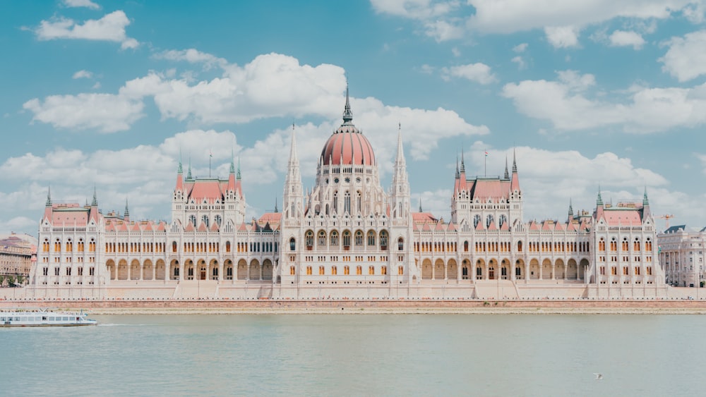 un gran edificio con un techo abovedado con el edificio del Parlamento húngaro en el fondo