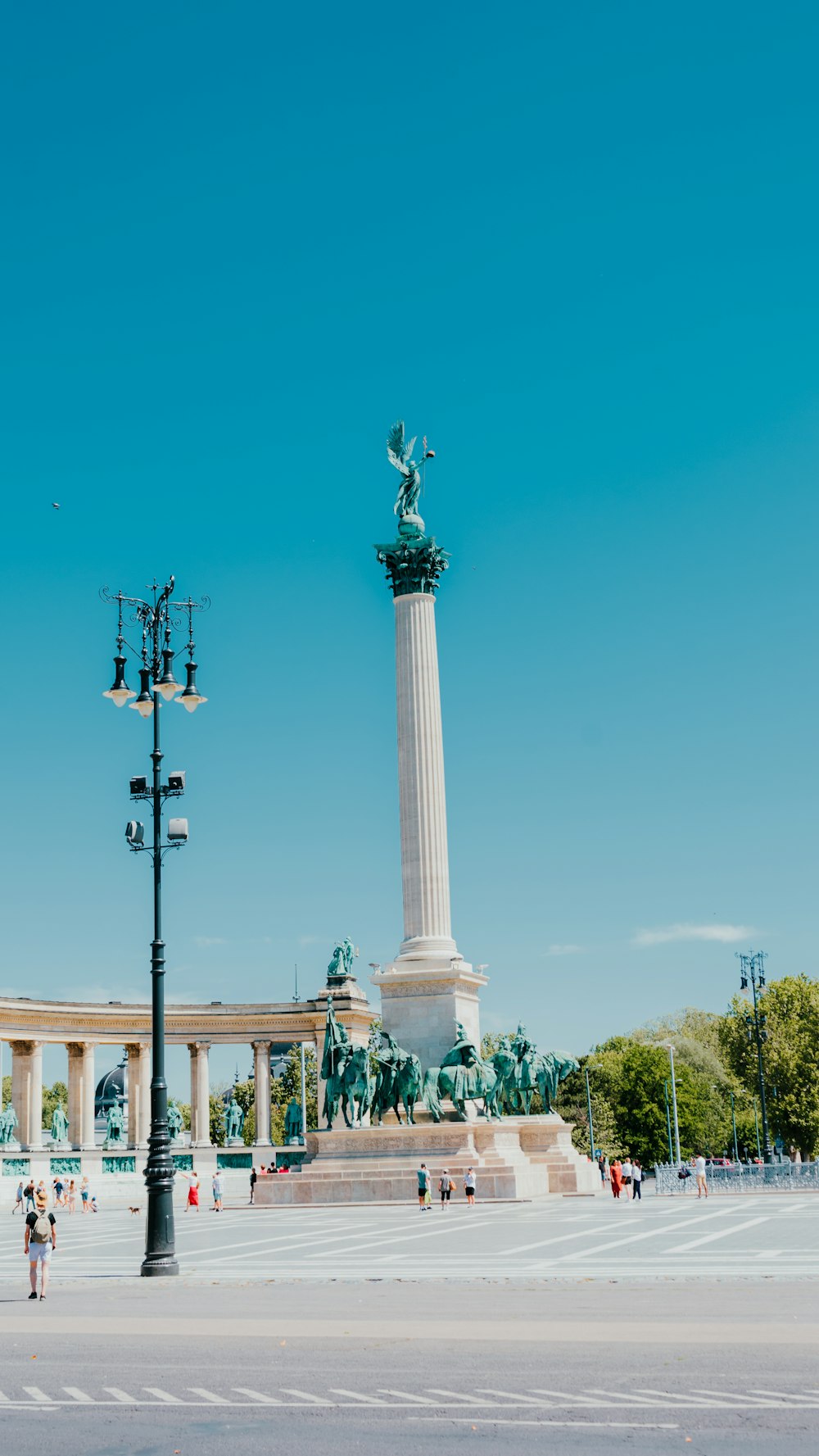 Una estatua de una persona sosteniendo una antorcha frente a un monumento