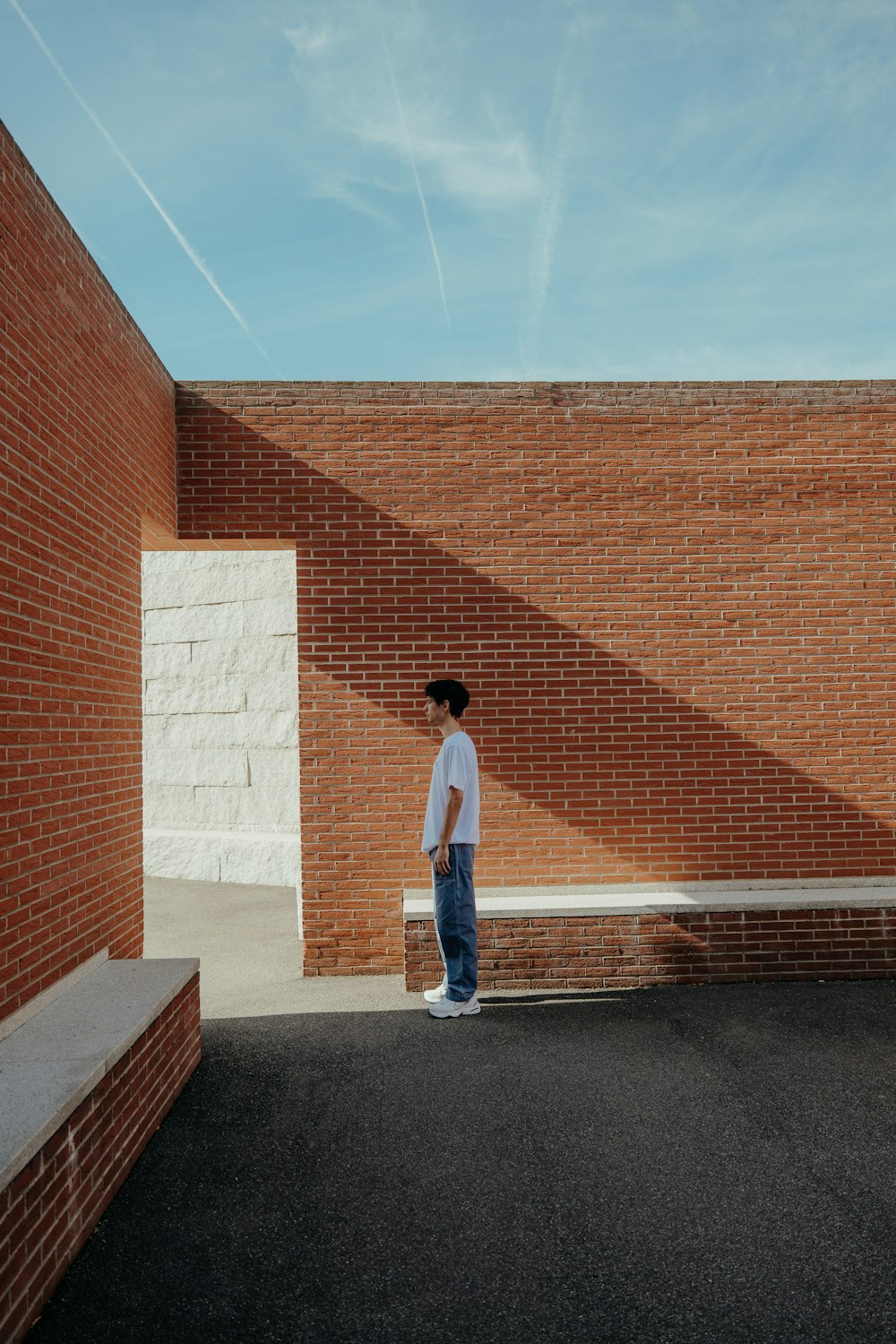 a man standing in front of a brick wall