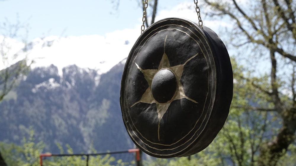 a metal object with a round hole in it with trees in the back