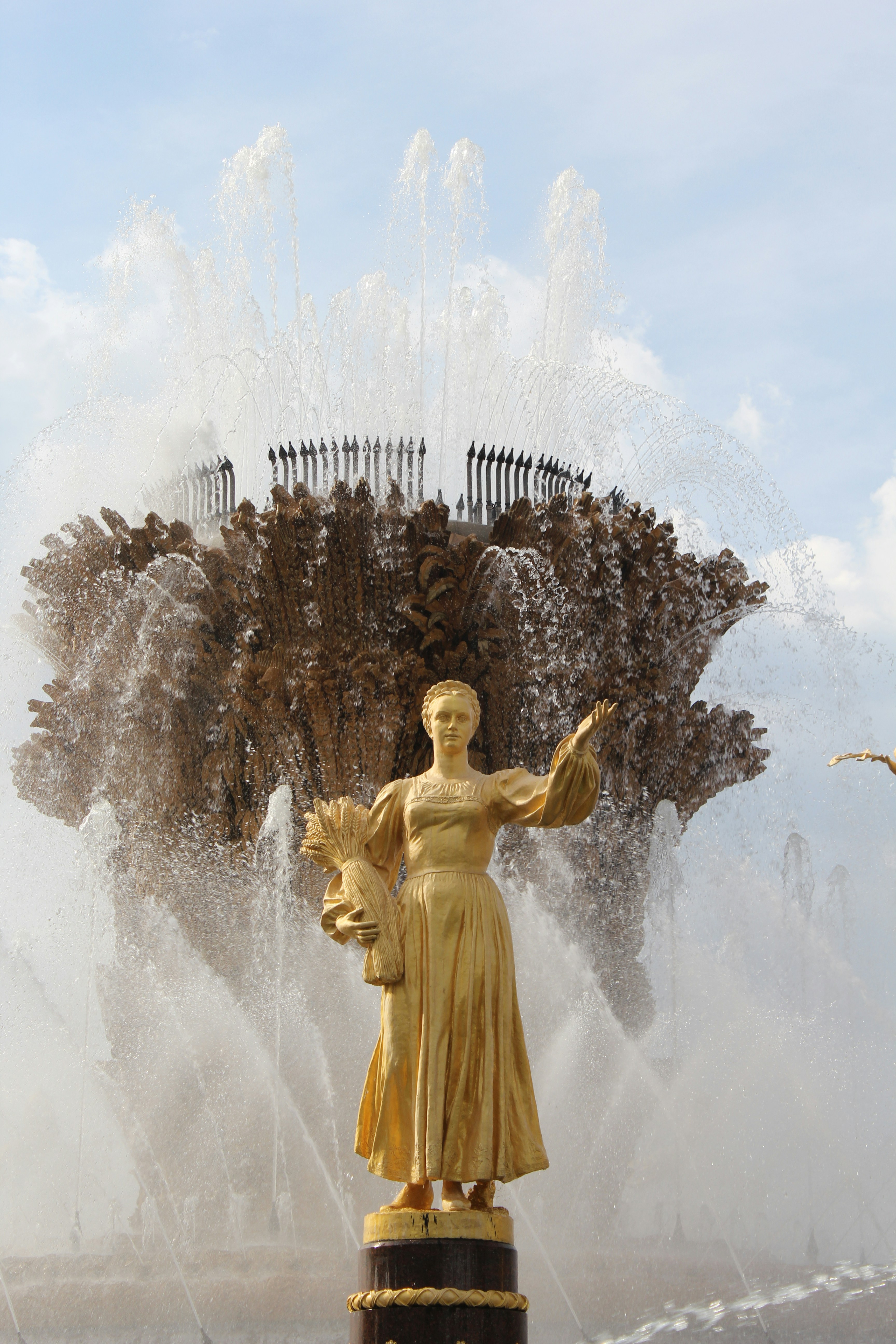 a statue of a person holding a torch in front of a fountain