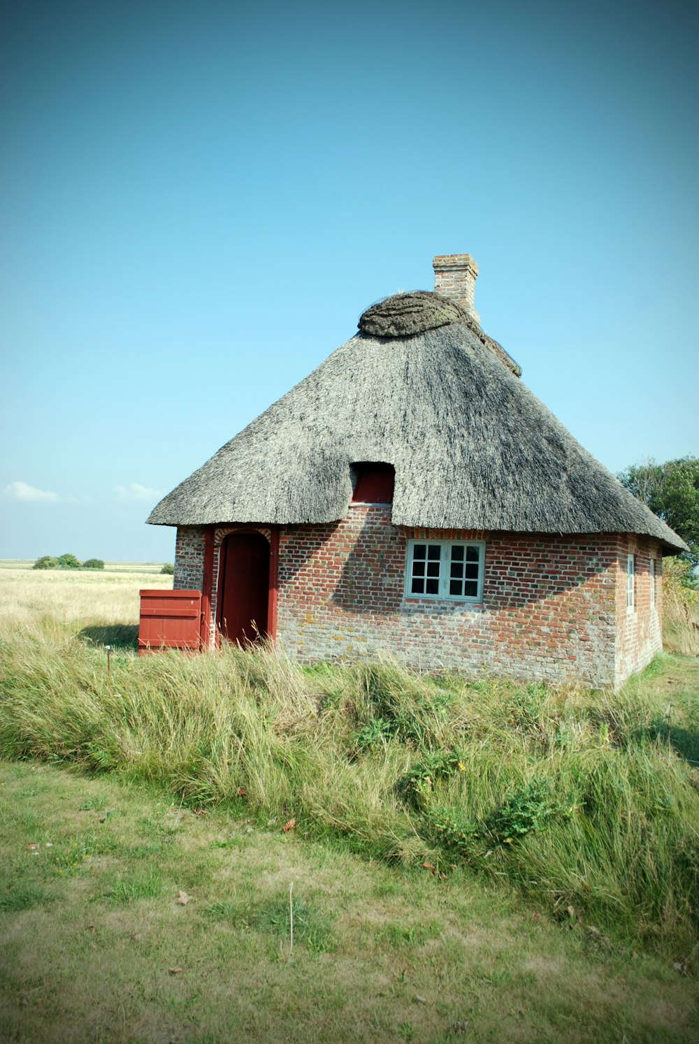 a brick house in a grassy field