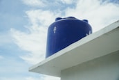 a blue cylindrical object on a white building