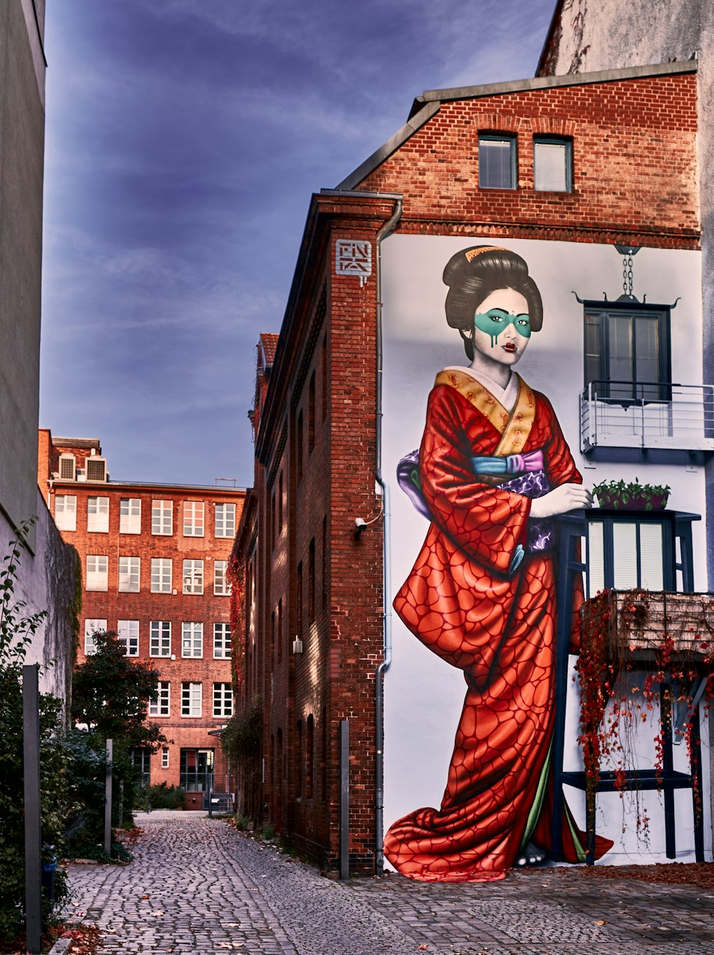a painting of a person in a red robe and sunglasses on a brick building
