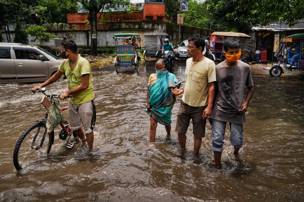 a group of people stand in a flooded street