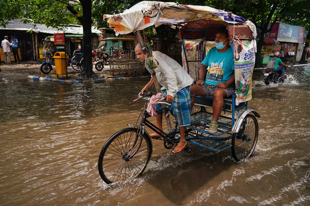 a person riding a bicycle through a flooded street