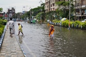 people walking in a flooded street