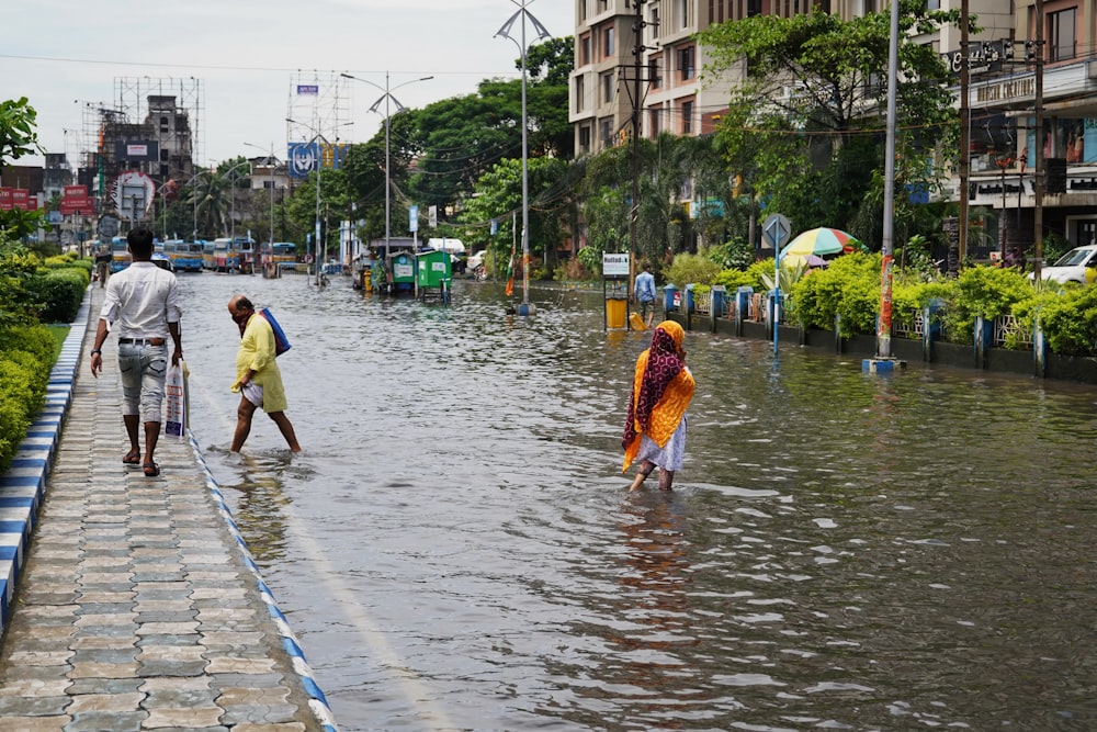 people walking in a flooded street