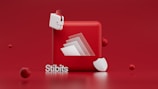A red background is the setting for a 3D composition consisting of a red cube with a folded paper effect on its surface. Surrounding the cube are smaller spheres and a white shield-like shape. Additionally, a small, abstract white and red object resembling a wallet is present. The word 'Stibits' appears prominently in white letters at the bottom left.