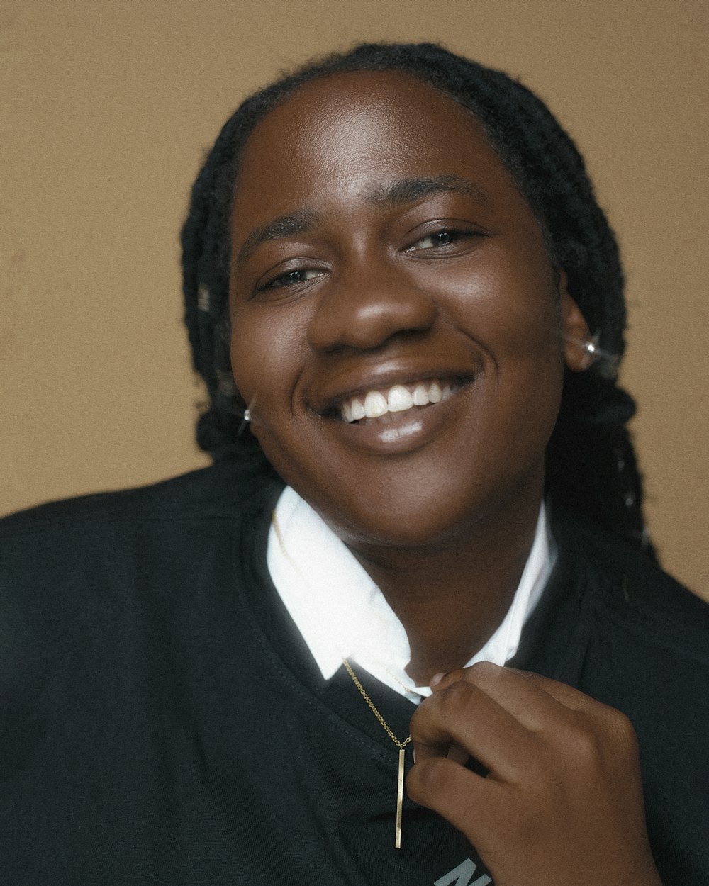 a man smiling and wearing a white shirt