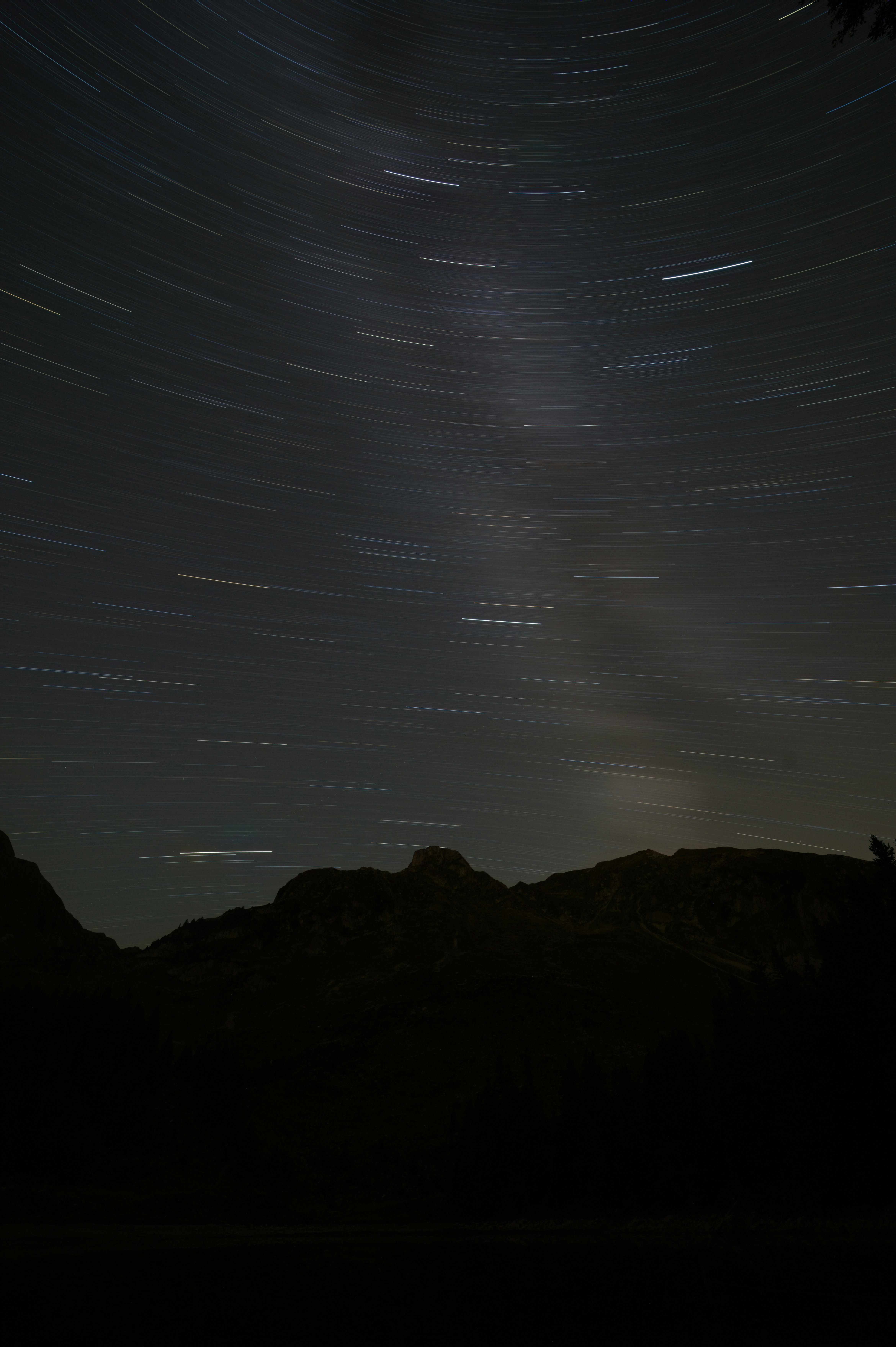 a view of the night sky with stars and a mountain range