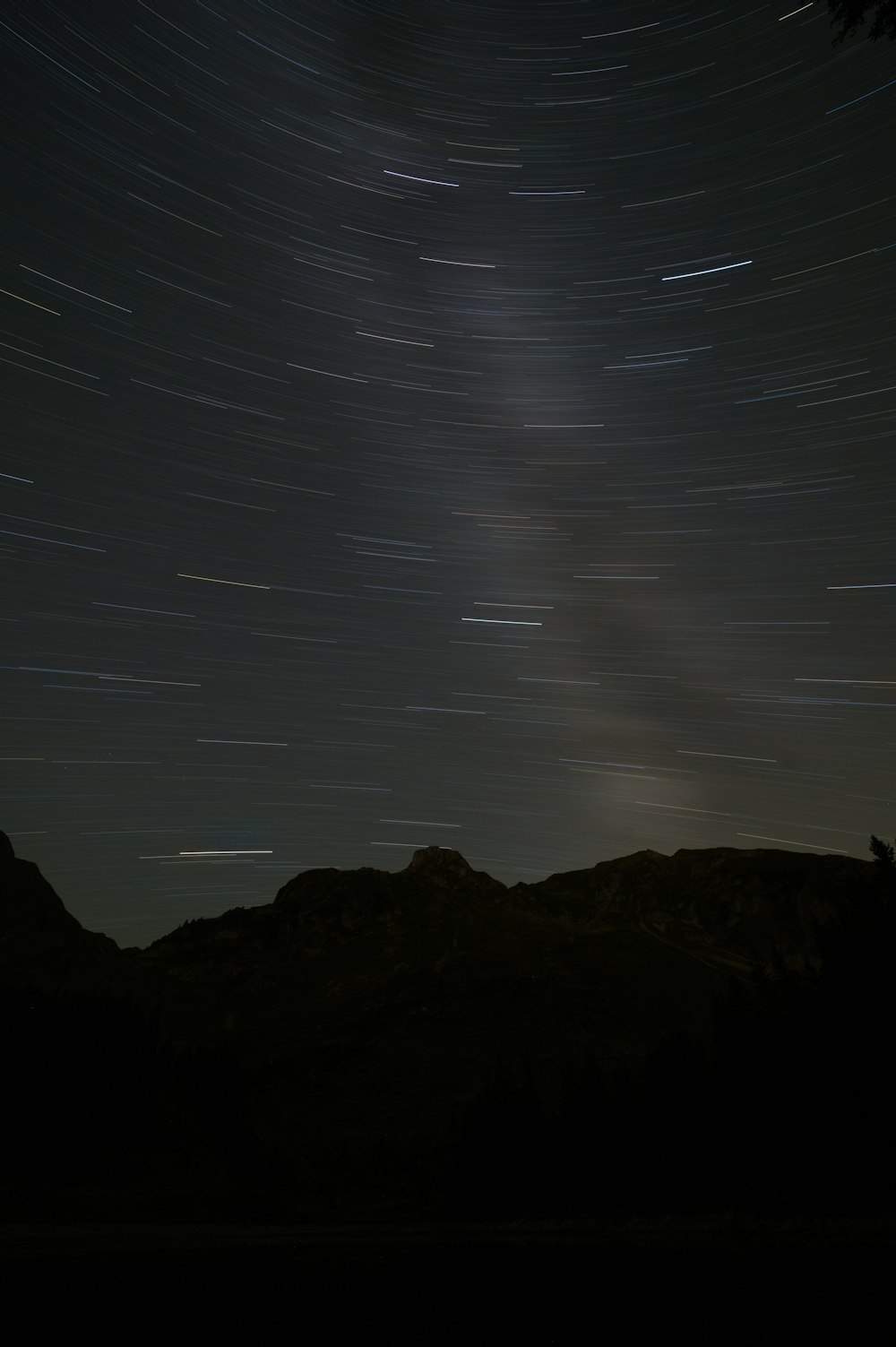 a view of the night sky with stars and a mountain range