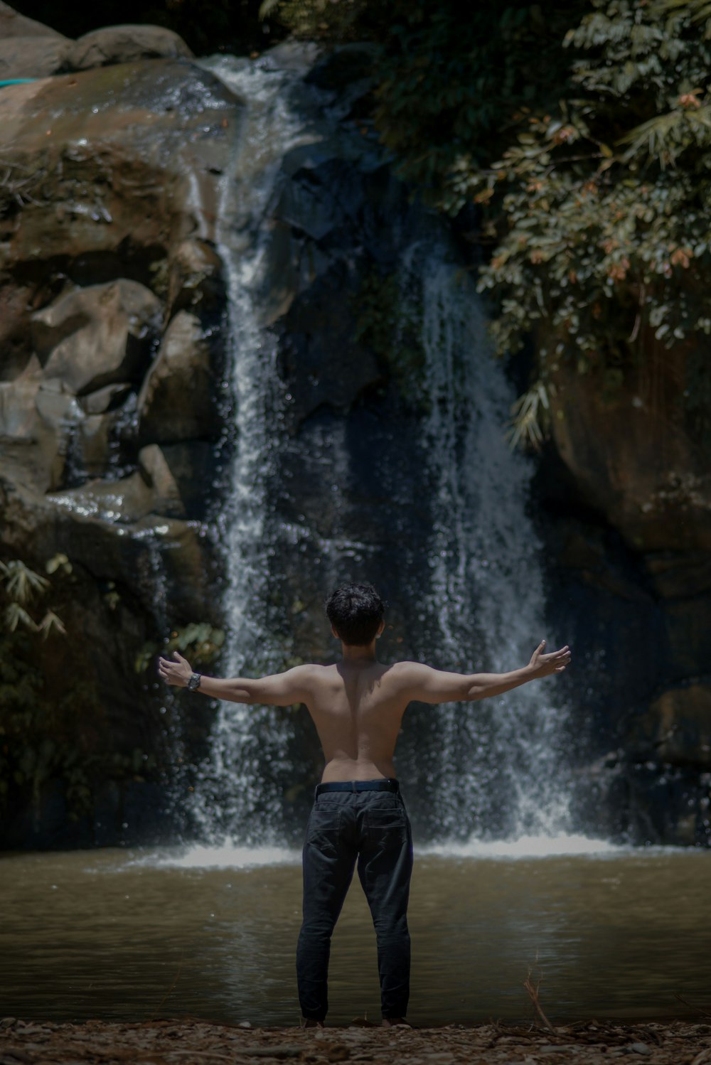 a man standing in front of a waterfall