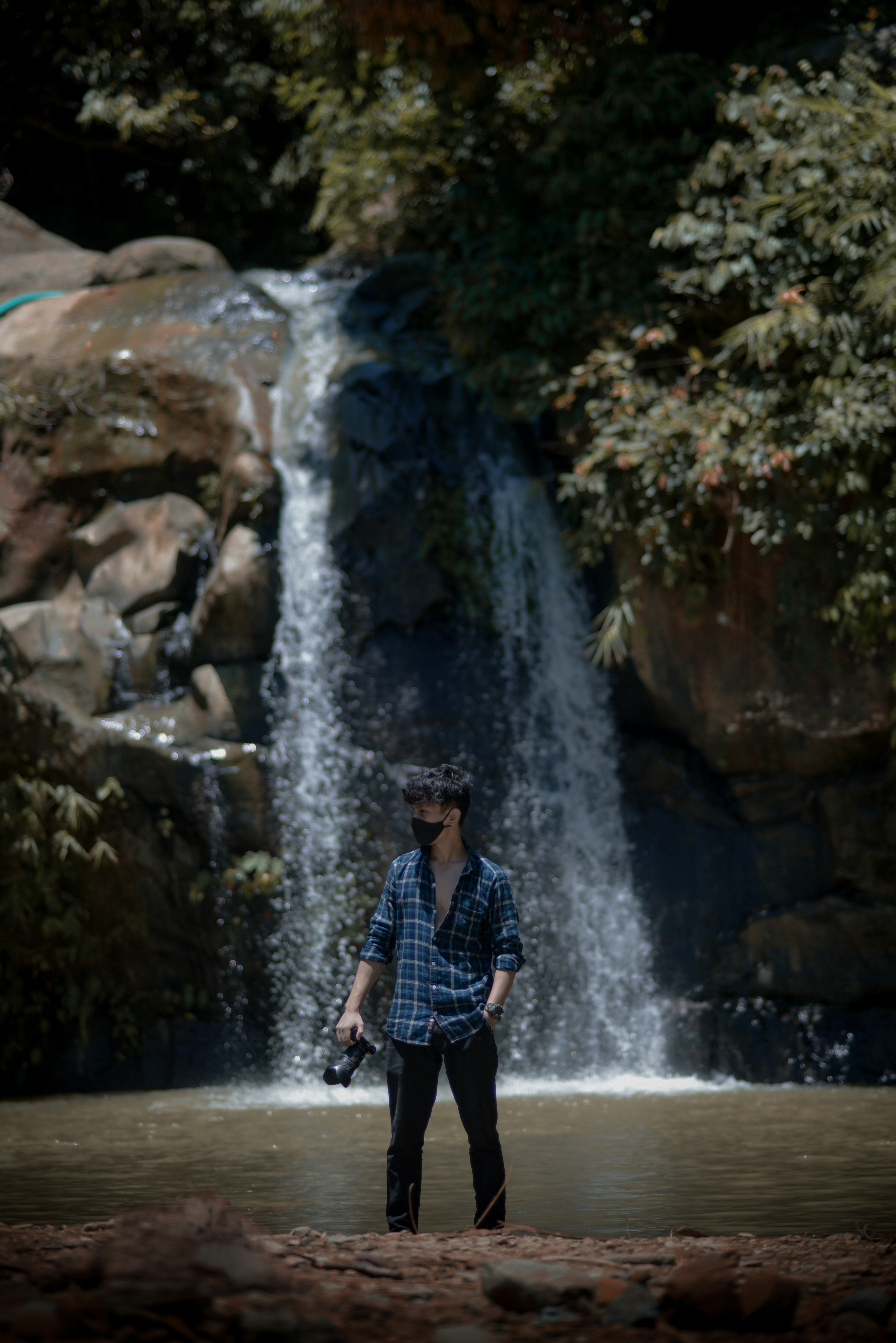 a man standing in front of a waterfall
