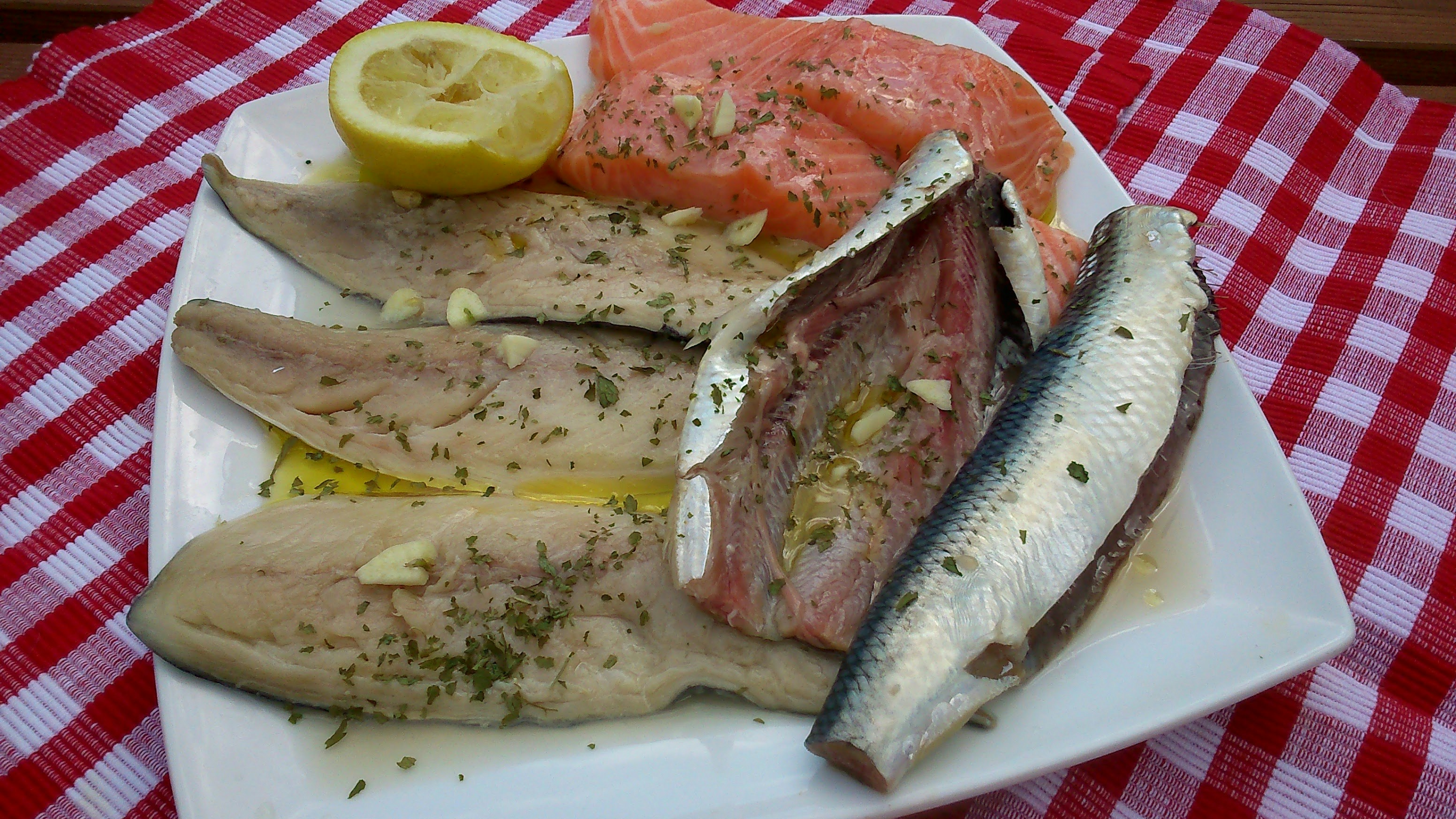 Salmon Fish On A Plate With Skin, Garnished With Herbs And Lemon