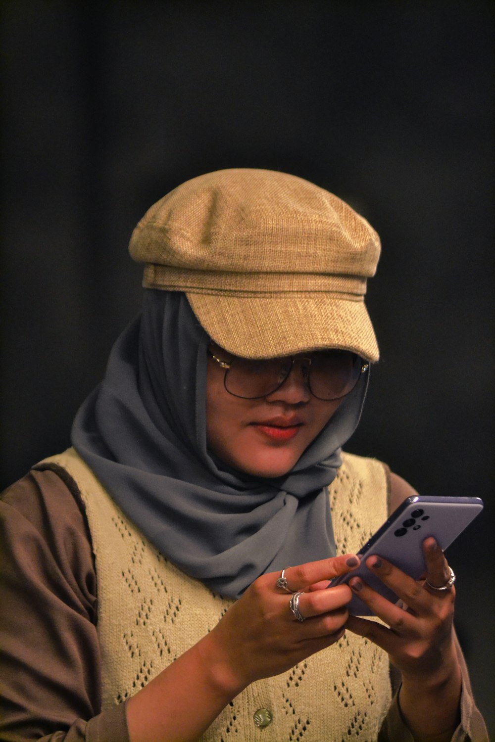 Un hombre con sombrero y gafas sosteniendo un teléfono